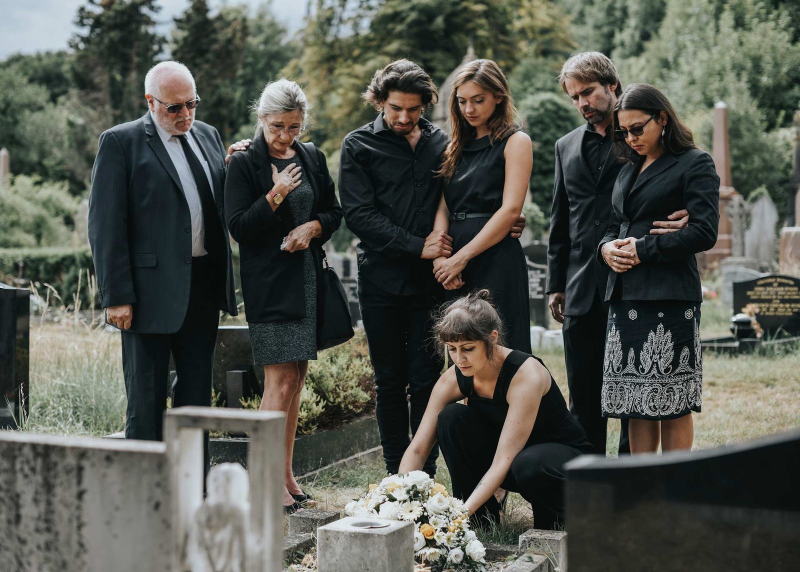 family-laying-flowers-on-the-grave-QKURHPX.jpg